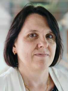 Claudia Felser mit kurzem, dunklem Bob-Haarschnitt und weißer Kleidung.